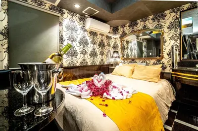 a hotel room with a bed with a table and glasses at \u30db\u30c6\u30eb\u30ea\u30aa\u30b9\u6e0b\u8c37Adults only in Tokyo