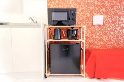 a small refrigerator in a kitchen with a tv on a shelf at #41 -Japanese-Retreat Inn- \u5800\u5207 in Tokyo
