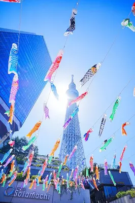 a group of kites flying in front of a tall building at #41 -Japanese-Retreat Inn- \u5800\u5207 in Tokyo