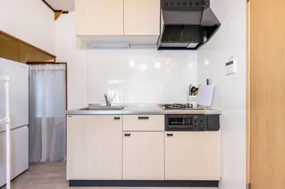 a white kitchen with a sink and a stove at SUSHI STAY tokyo in Tokyo