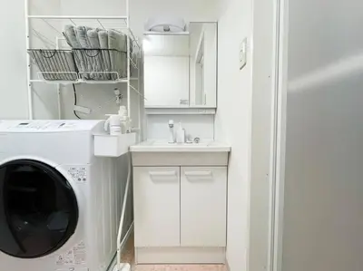 a white laundry room with a washing machine and a sink at SUSHI STAY tokyo in Tokyo