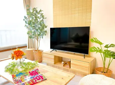 a living room with a flat screen tv and plants at SUSHI STAY tokyo in Tokyo