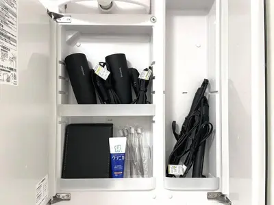 a white cabinet filled with black umbrellas at SUSHI STAY tokyo in Tokyo