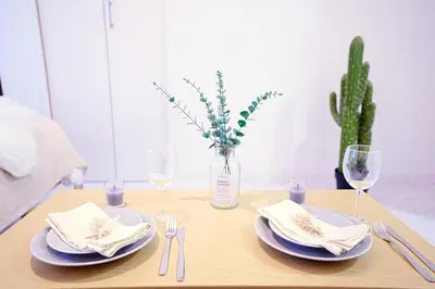 a table with plates and glasses and a vase with a cactus at Nordic-Retreat Inn in Tokyo
