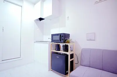 a room with a couch and a microwave on a table at Nordic-Retreat Inn in Tokyo