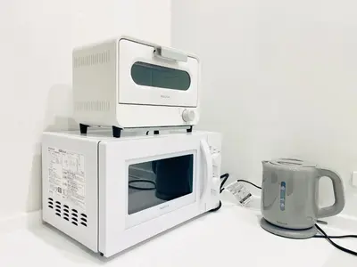a microwave oven with a computer on top of it at Kita-Ueno Inn - Near UENO, ASAKUSA, SENSOJI, TOKYO SKY TREE - Self check-in in Tokyo