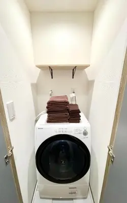 a laundry room with a washing machine with towels on it at Kita-Ueno Inn - Near UENO, ASAKUSA, SENSOJI, TOKYO SKY TREE - Self check-in in Tokyo