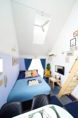 a bedroom with a blue bed and a tv at SC 206 Cozy Private Stay with Loft Near Station Free WiFi in Tokyo