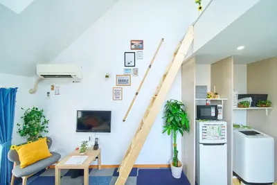 a living room with a staircase on the wall at SC 206 Cozy Private Stay with Loft Near Station Free WiFi in Tokyo