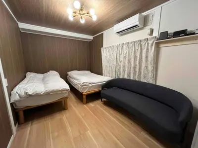 a small room with two beds and a ceiling fan at Cozy inn \u897f\u54c1\u5ddd101 in Tokyo