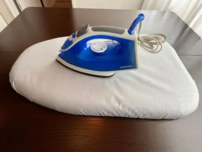a blue iron sitting on a white pillow on a table at Cozy inn \u897f\u54c1\u5ddd101 in Tokyo