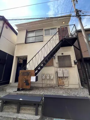 a house with a staircase and a bench in front of it at Cozy inn \u897f\u54c1\u5ddd101 in Tokyo