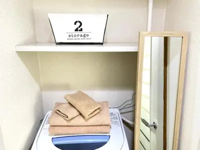 a shelf with towels sitting on top of a toilet at \u65b0\u5bbf\u306e\u5bbf in Tokyo