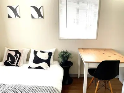 a bedroom with a bed and a desk and a table at \u65b0\u5bbf\u306e\u5bbf in Tokyo