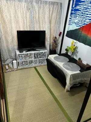 a living room with a flat screen tv on a table at Yuki House in Tokyo