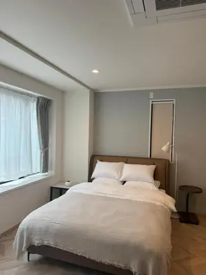 a bedroom with a large bed with a large window at the one ueno in Tokyo