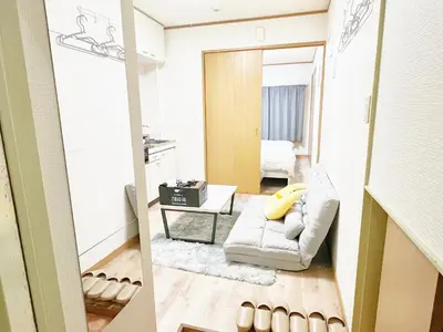 a living room with a white couch and a mirror at \u897f\u6b66\u65b0\u5bbf\u7dda \u99c5\u8fd16\u4eba\u53ef d1 in Tokyo