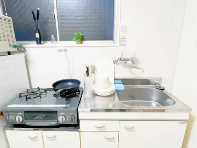 a kitchen with a stove and a sink at \u897f\u6b66\u65b0\u5bbf\u7dda \u99c5\u8fd16\u4eba\u53ef d1 in Tokyo