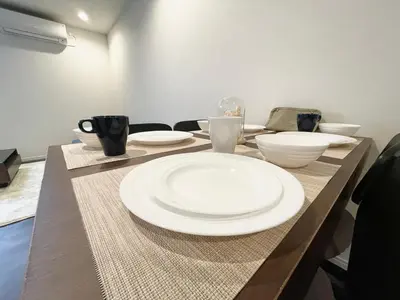 a table with white plates and bowls on it at New\u4e09\u8ed2\u8336\u5c4b\u30cf\u30a6\u30b9 \u6e0b\u8c37\u307e\u3067\u96fb\u8eca5\u5206 \u4e09\u8ed2\u8336\u5c4b\u99c5\u5f92\u6b696\u5206 2023\u5e74\u30d5\u30eb\u30ea\u30ce\u30d9\u6238\u5efa in Tokyo