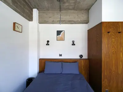 a bedroom with a blue bed with a wooden headboard at NO SERVICE HOTEL azumabashi in Tokyo