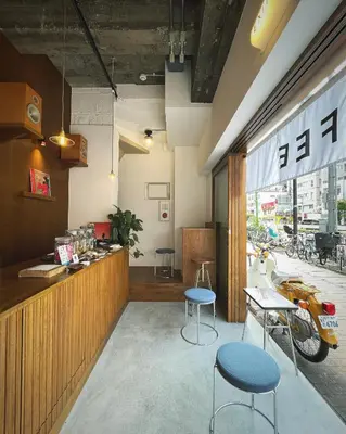 a restaurant with two tables and two stools in front of a counter at NO SERVICE HOTEL azumabashi in Tokyo
