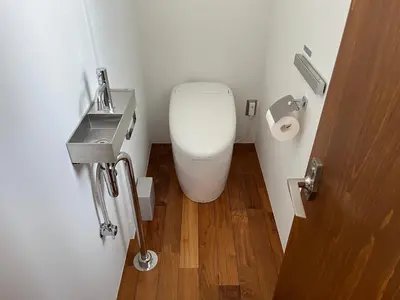 a bathroom with a toilet and a sink and a door at NO SERVICE HOTEL azumabashi in Tokyo