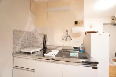a kitchen with a sink and a refrigerator at Jarudan in Tokyo