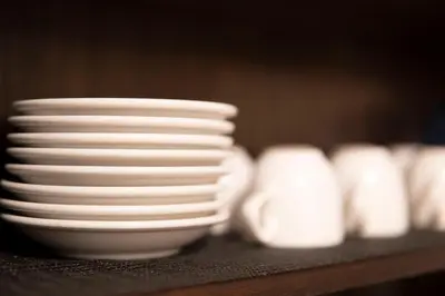 a stack of white plates and bowls sitting on a table at Jarudan in Tokyo