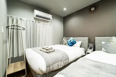 a bedroom with two beds and a air conditioner at 74, Yotsugi, Entire house for rent, \u56db\u3064\u6728 in Tokyo