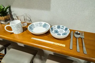 a wooden table with two bowls and utensils on it at 74, Yotsugi, Entire house for rent, \u56db\u3064\u6728 in Tokyo