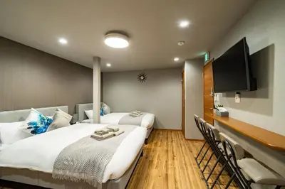a hotel room with two beds and a flat screen tv at 74, Yotsugi, Entire house for rent, \u56db\u3064\u6728 in Tokyo