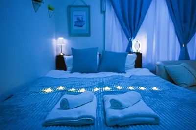 a blue bedroom with a bed with towels on it at #40 -Siro House- \u5800\u5207 in Tokyo