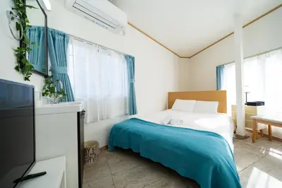 a bedroom with a bed with a blue blanket at 38, Kyojima 3, Entire house for rent, \u4eac\u5cf63\u4e01\u76ee in Tokyo