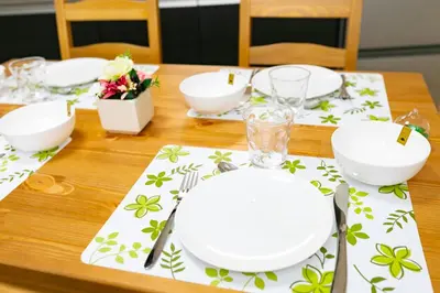 a wooden table with white plates and napkins on it at 38, Kyojima 3, Entire house for rent, \u4eac\u5cf63\u4e01\u76ee in Tokyo