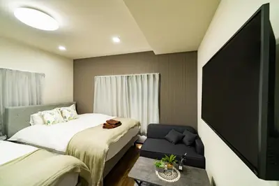 a bedroom with two beds and a flat screen tv at 72, Nakanobu A, Entire house for rent, \u4e2d\u5ef6A in Tokyo