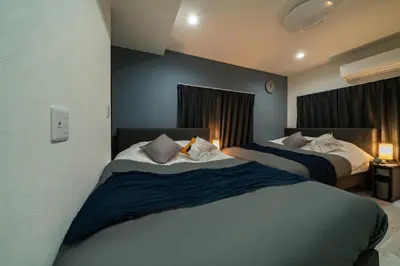 a hotel room with two beds and two windows at 96, Tateishi A, Entire house for rent, \u7acb\u77f3A in Tokyo