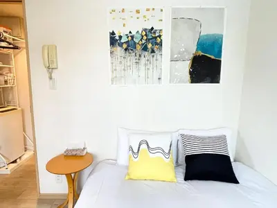 a bedroom with a bed with two pillows and a table at \u30b7\u30e3\u30f3\u30c6\u9ad8\u7530\u99ac\u583422 in Tokyo