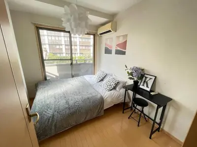 a bedroom with a bed and a table and a window at \u30b7\u30e3\u30f3\u30c6\u9ad8\u7530\u99ac\u583431 in Tokyo