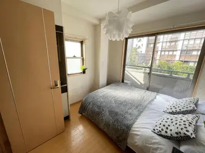 a bedroom with a bed with pillows and a window at \u30b7\u30e3\u30f3\u30c6\u9ad8\u7530\u99ac\u583431 in Tokyo