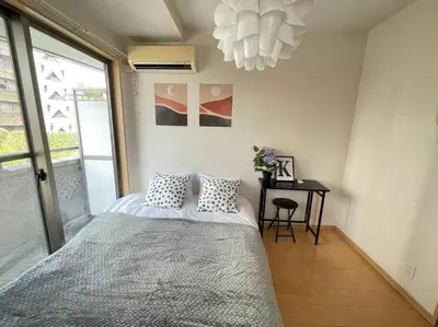 a bedroom with a bed and a desk and a chandelier at \u30b7\u30e3\u30f3\u30c6\u9ad8\u7530\u99ac\u583431 in Tokyo