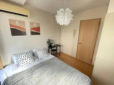 a bedroom with a large bed and a chandelier at \u30b7\u30e3\u30f3\u30c6\u9ad8\u7530\u99ac\u583431 in Tokyo