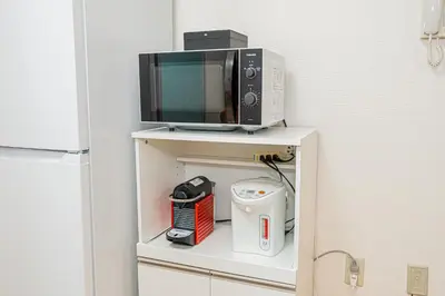 a microwave oven sitting on top of a shelf at KYARA Hotel\u30df\u30b9\u30df202 in Tokyo
