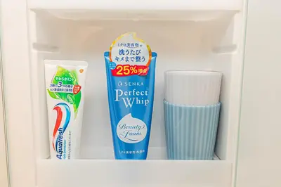 a shelf with toothbrushes tooth paste and toothpaste at KYARA Hotel\u30df\u30b9\u30df202 in Tokyo