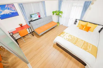 a bedroom with a bed and a couch and a table at KYARA Hotel\u30df\u30b9\u30df202 in Tokyo