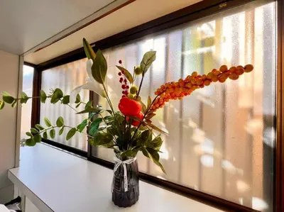 a vase of flowers sitting on a table next to a window at FUKU House in Tokyo