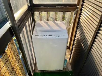 a small white refrigerator sitting in a cage at FUKU House in Tokyo