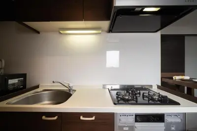 a kitchen with a sink and a stove at G112\u65b0\u5bbf\u6700\u4e2d\u5fc3 \u4ea4\u901a\u67a2\u7ebd \u8d85\u7ea7\u5546\u5708 \u4e24\u5ba4\u4e00\u5385 \u65b0\u5bbf\u4e09\u4e01\u76ee\u8f66\u7ad94\u5206 2 rooms Shinjuku center 4 mins to ST Max 7P \u76f4\u8fbe\u65b0\u5bbf \u6d89\u8c37 \u8868\u53c2\u9053 \u6c60\u888b \u4e0a\u91ce \u4ee3\u4ee3\u6728 \u94f6\u5ea7 \u539f\u5bbf in Tokyo