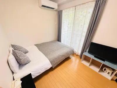 a bedroom with a bed and a flat screen tv at \u30b7\u30e3\u30f3\u30c6\u9ad8\u7530\u99ac\u583432 in Tokyo