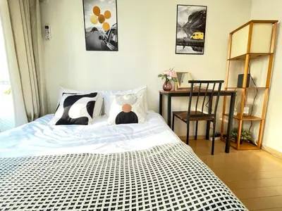 a man sitting on a bed in a bedroom at \u30b7\u30e3\u30f3\u30c6\u9ad8\u7530\u99ac\u583441 in Tokyo