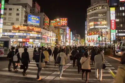 a group of people crossing a busy city street at night at \u30b7\u30e3\u30f3\u30c6\u9ad8\u7530\u99ac\u583442 in Tokyo